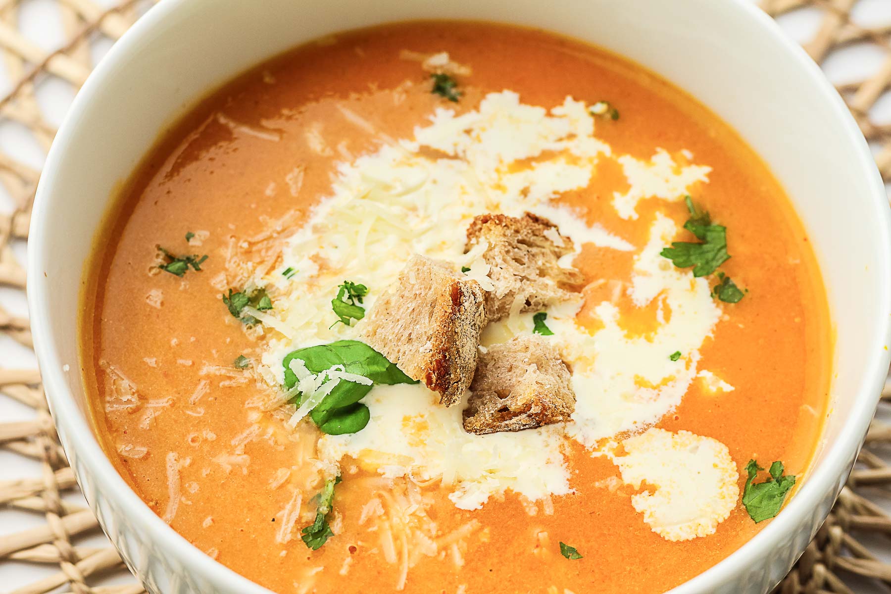 A bowl of tomato soup with garnish.