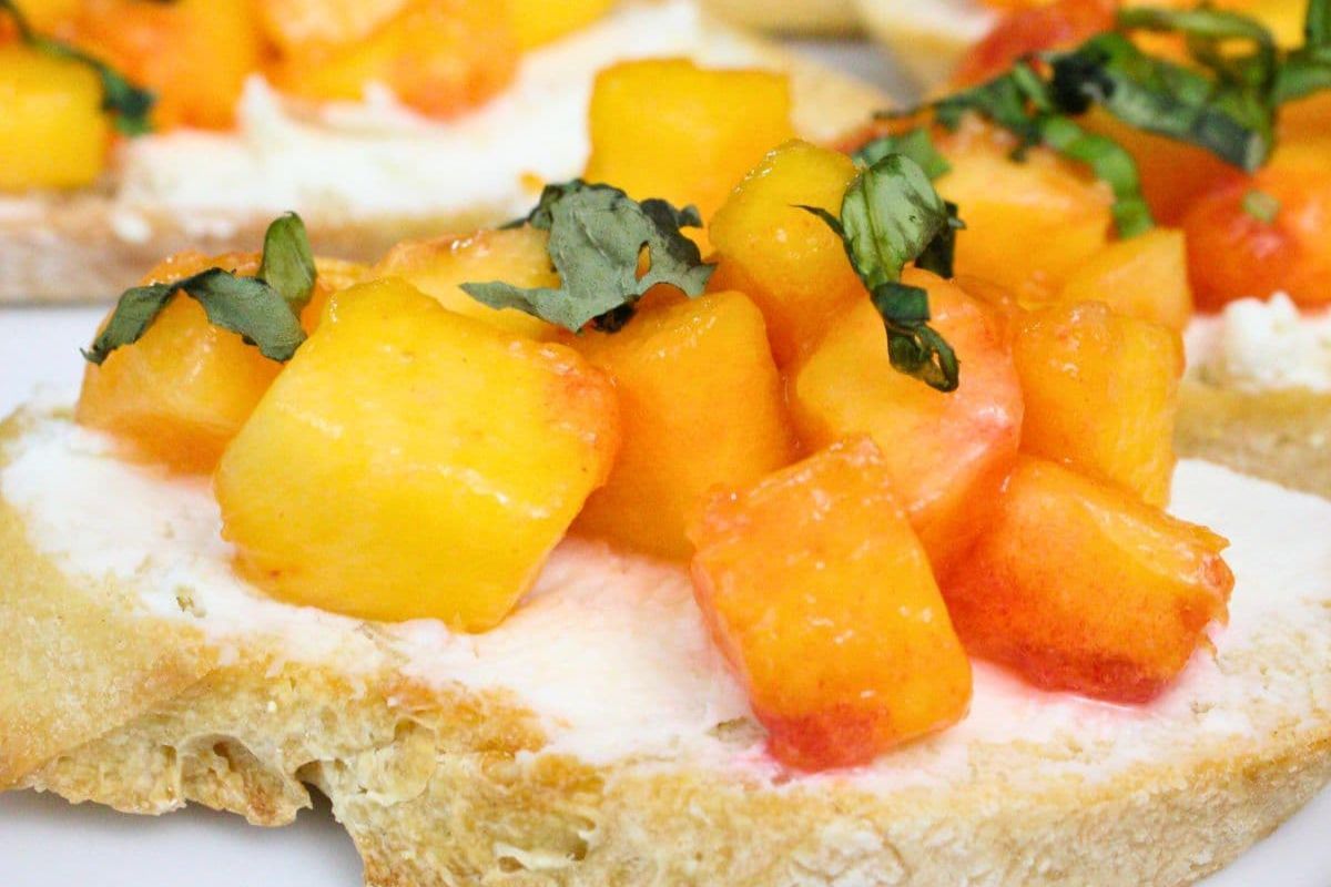 Toasted bread topped with cream cheese, diced peaches, and chopped fresh basil.