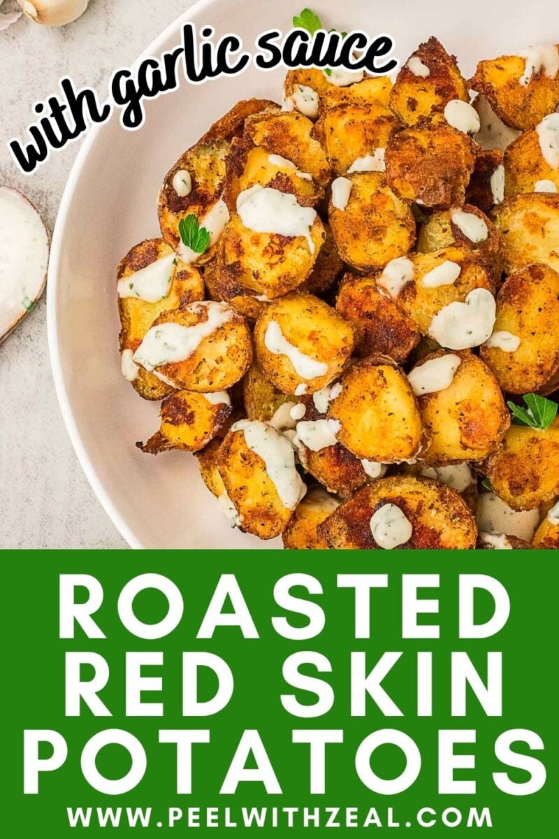 A bowl of roasted red skin potatoes drizzled with garlic sauce and garnished with fresh herbs sits on a white background. Text reads “Roasted Red Skin Potatoes” and “with garlic sauce.”.
