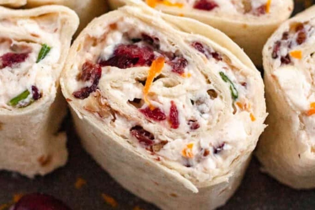Close-up of tortilla pinwheels filled with cream cheese, dried cranberries, green onions, and cheese—perfect party appetizers everyone will love.