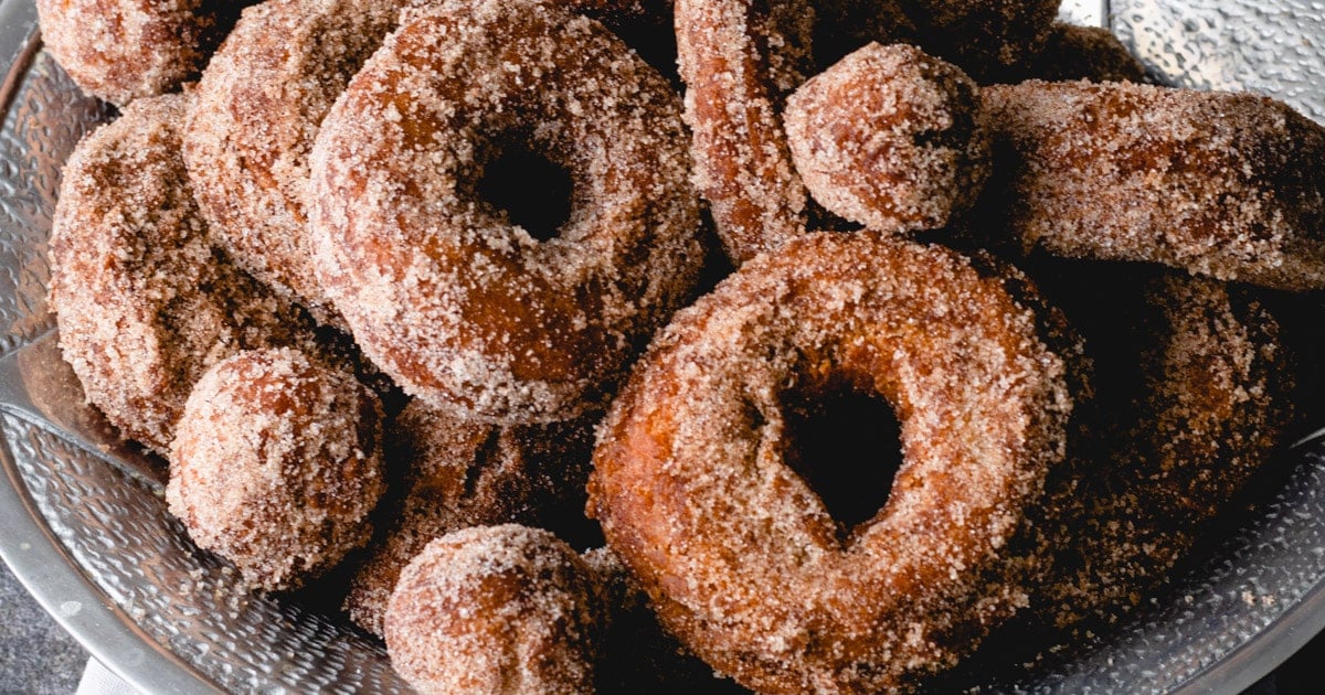 A bowl filled with sugar-coated donuts and donut holes, showcasing their golden-brown color and textured surface—these easy desserts are perfect for kids to enjoy during cozy Autumn desserts season.