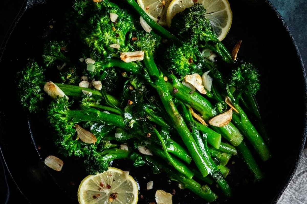Broccolini sautéed in a pan with sliced garlic, red pepper flakes, and lemon slices—one of the best healthy side dishes for chicken.