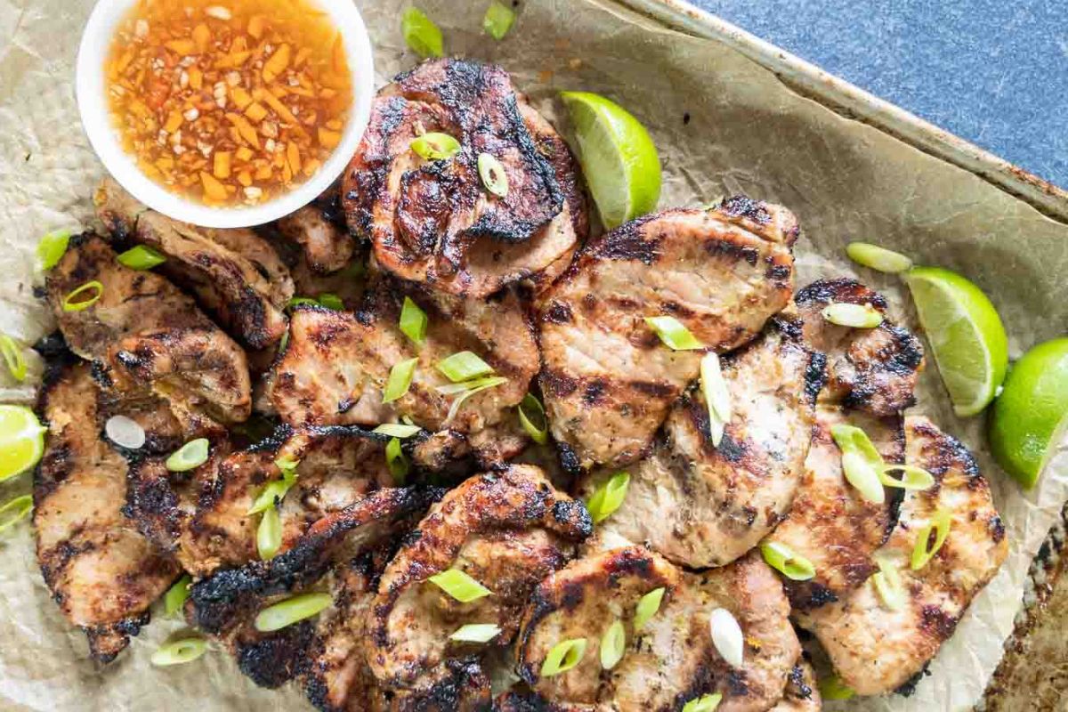 Grilled chicken pieces garnished with sliced green onions and lime wedges, served with a bowl of dipping sauce on a parchment-lined tray—this is one of those flavor-packed recipes that will elevate your dinner routine.