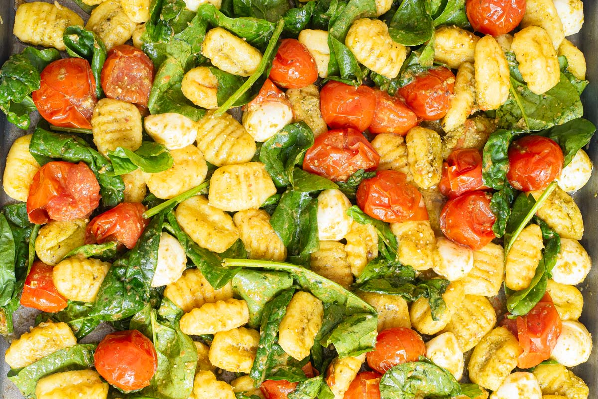 Gnocchi mixed with spinach, roasted cherry tomatoes, mozzarella balls, and pesto sauce—perfect for easy dinners and stress-free weeknight meals.