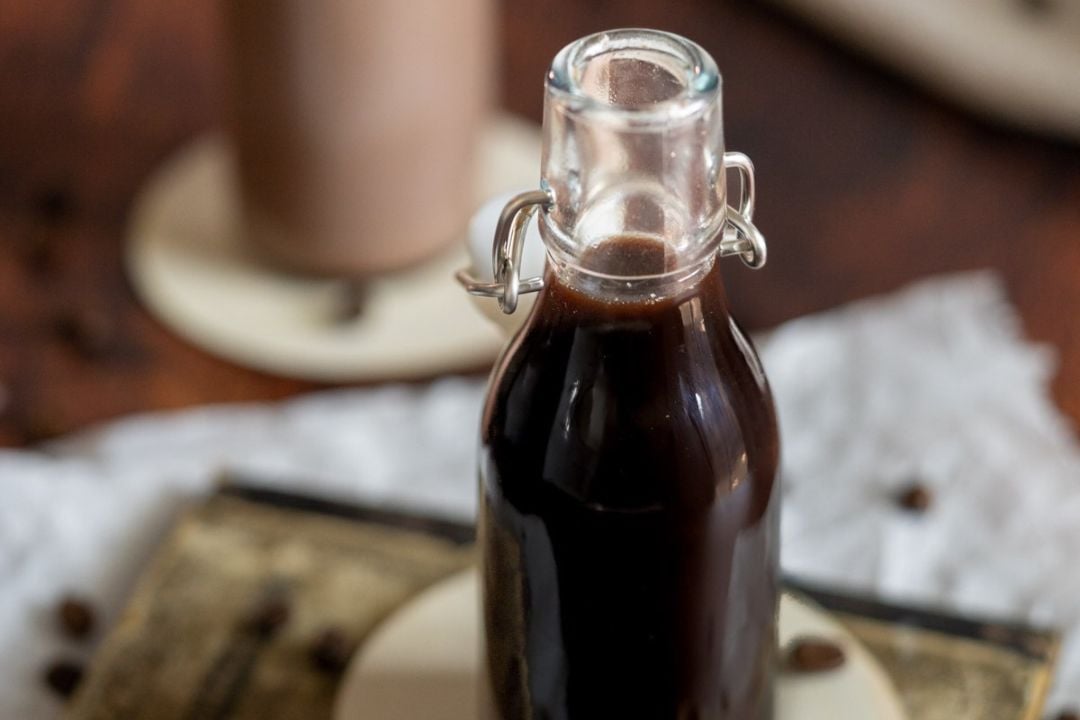 A glass swing-top bottle filled with a dark coffee concentrate.