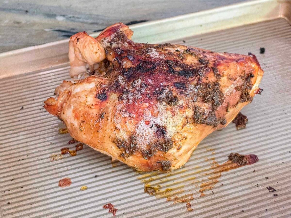 A slow cooker turkey breast, roasted and resting on a metal baking sheet.